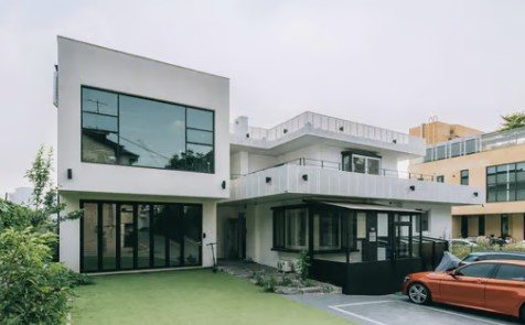 논스 라이트하우스 외관 — 잔디 마당이 있는 흰 2층 주택